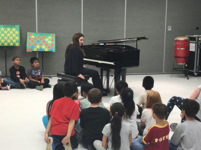 Photo of Simone Dinnerstein playing for a group of students